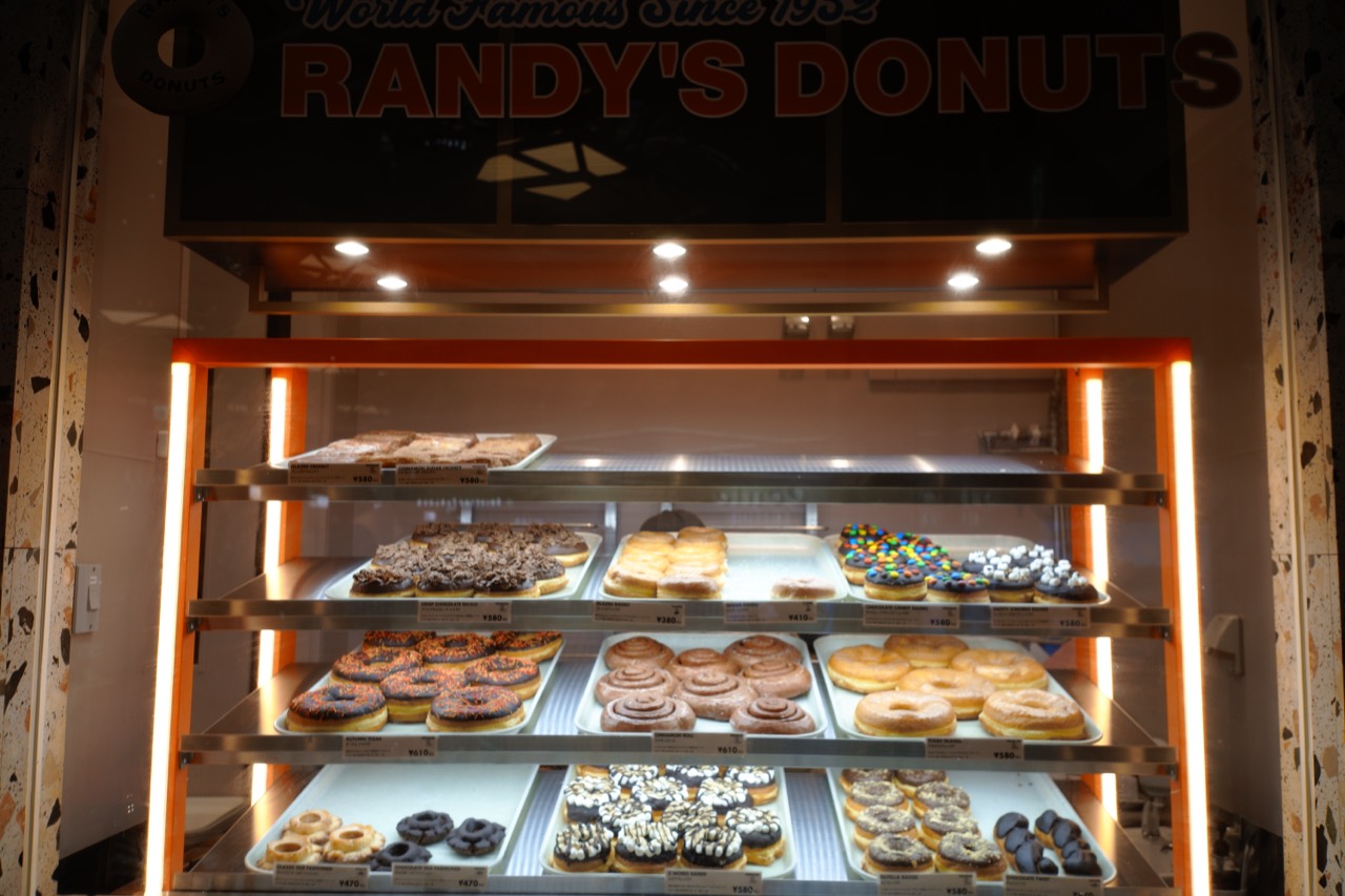 RANDY'S DONUTSの看板と、ドーナツが並ぶショーケース