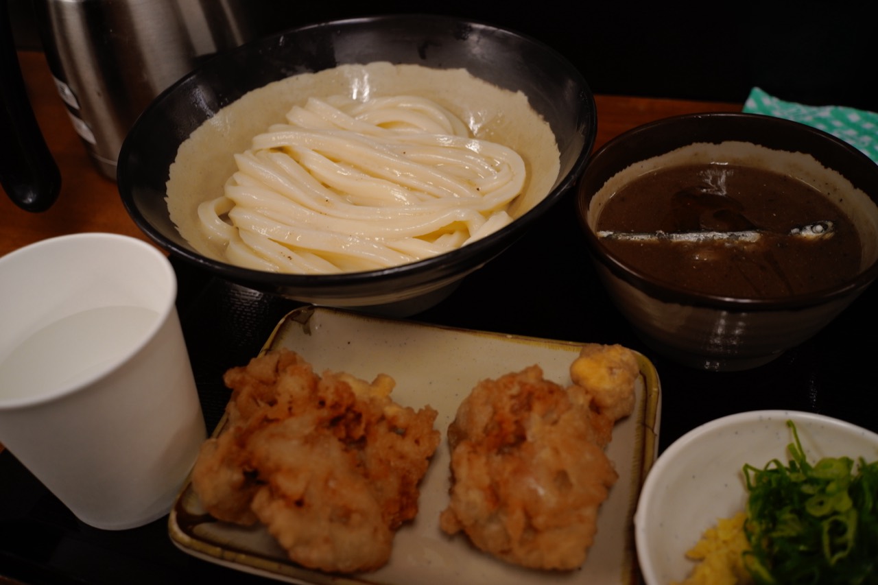 うどんとつけ汁、薬味が並ぶ食事