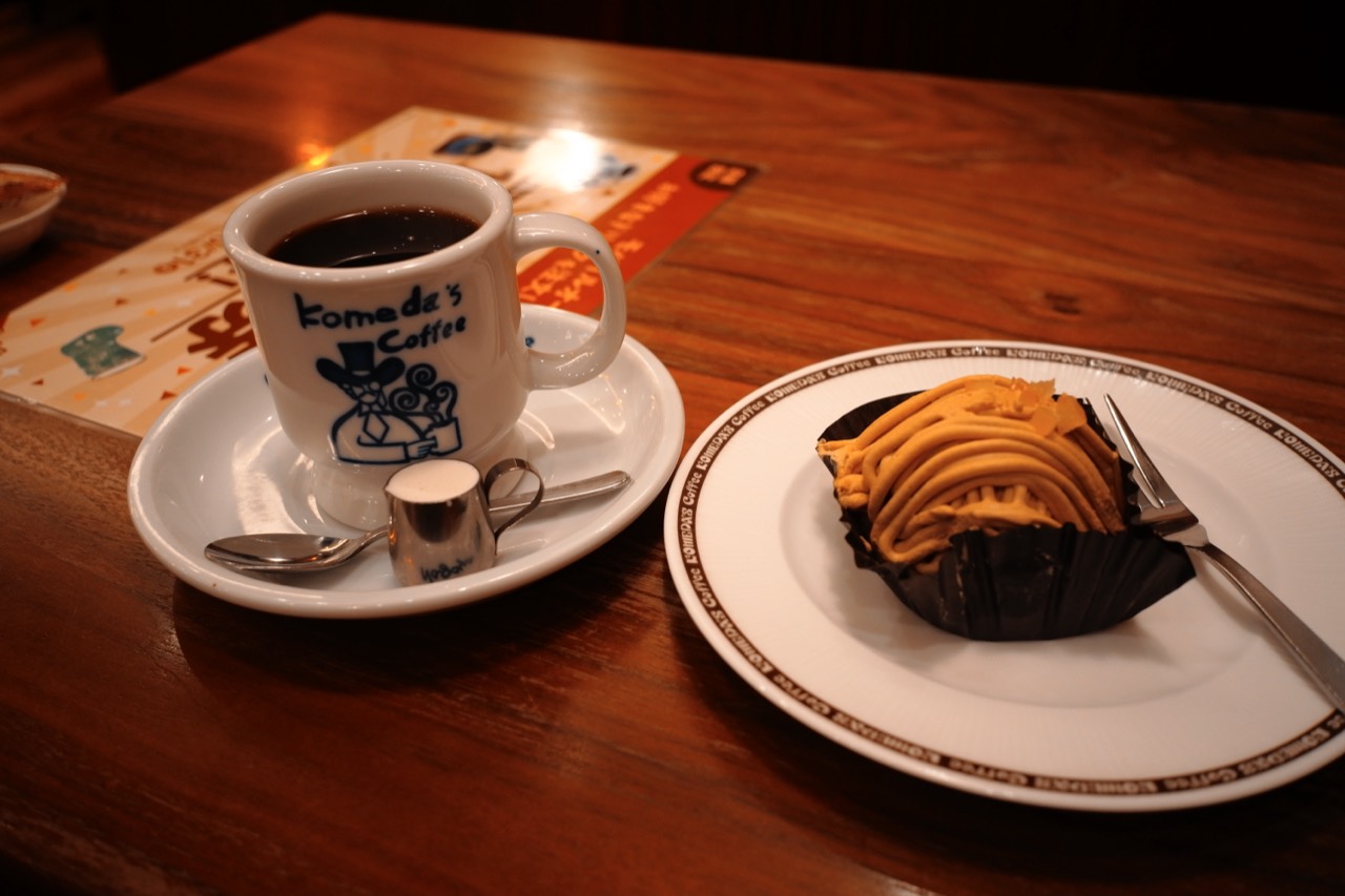 コメダのカップに入ったコーヒーと、隣の皿に載ったケーキ