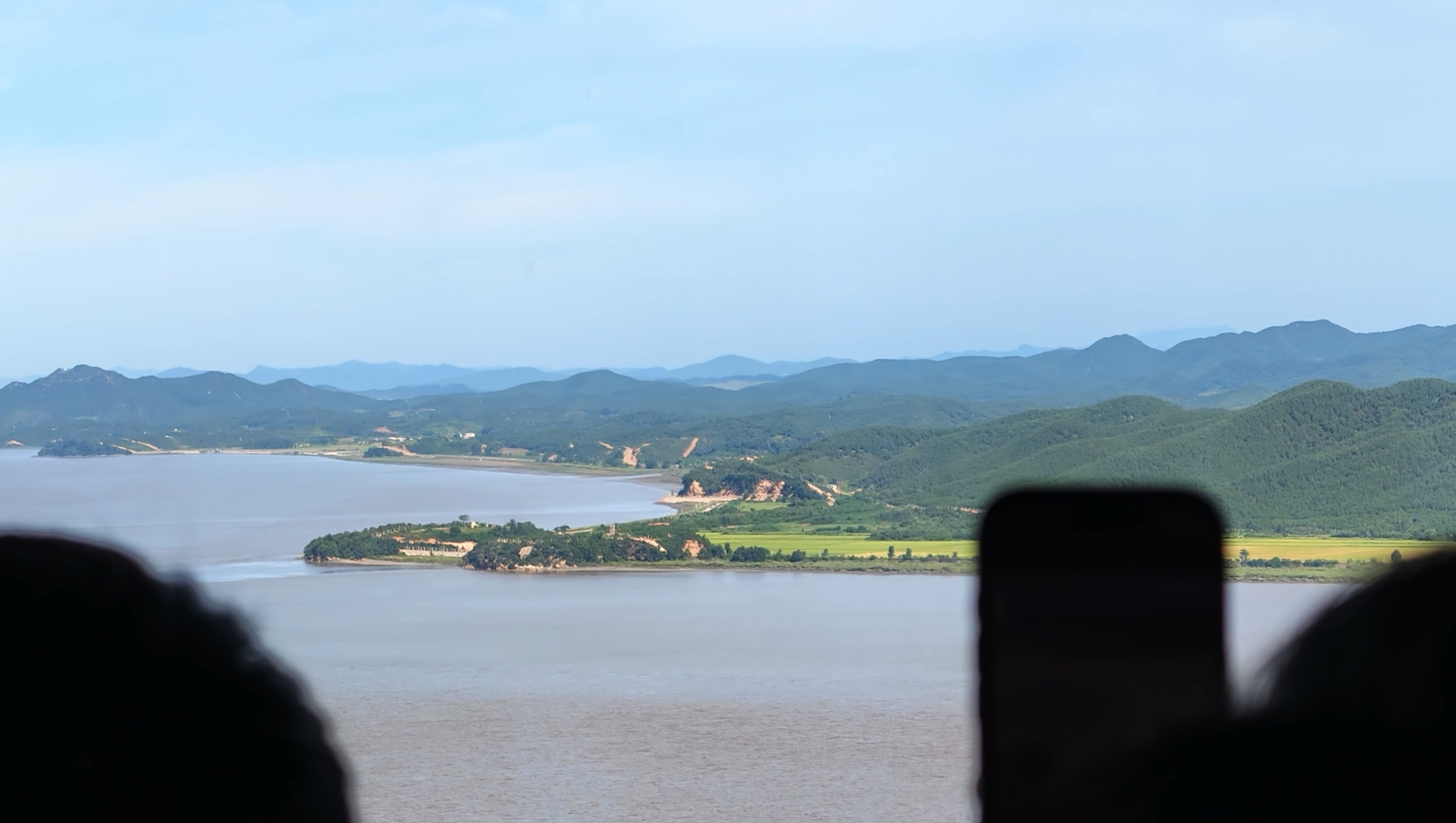 愛妓峰の展望台から見た景色。川の向こうに畑や緑の山並みが広がっている