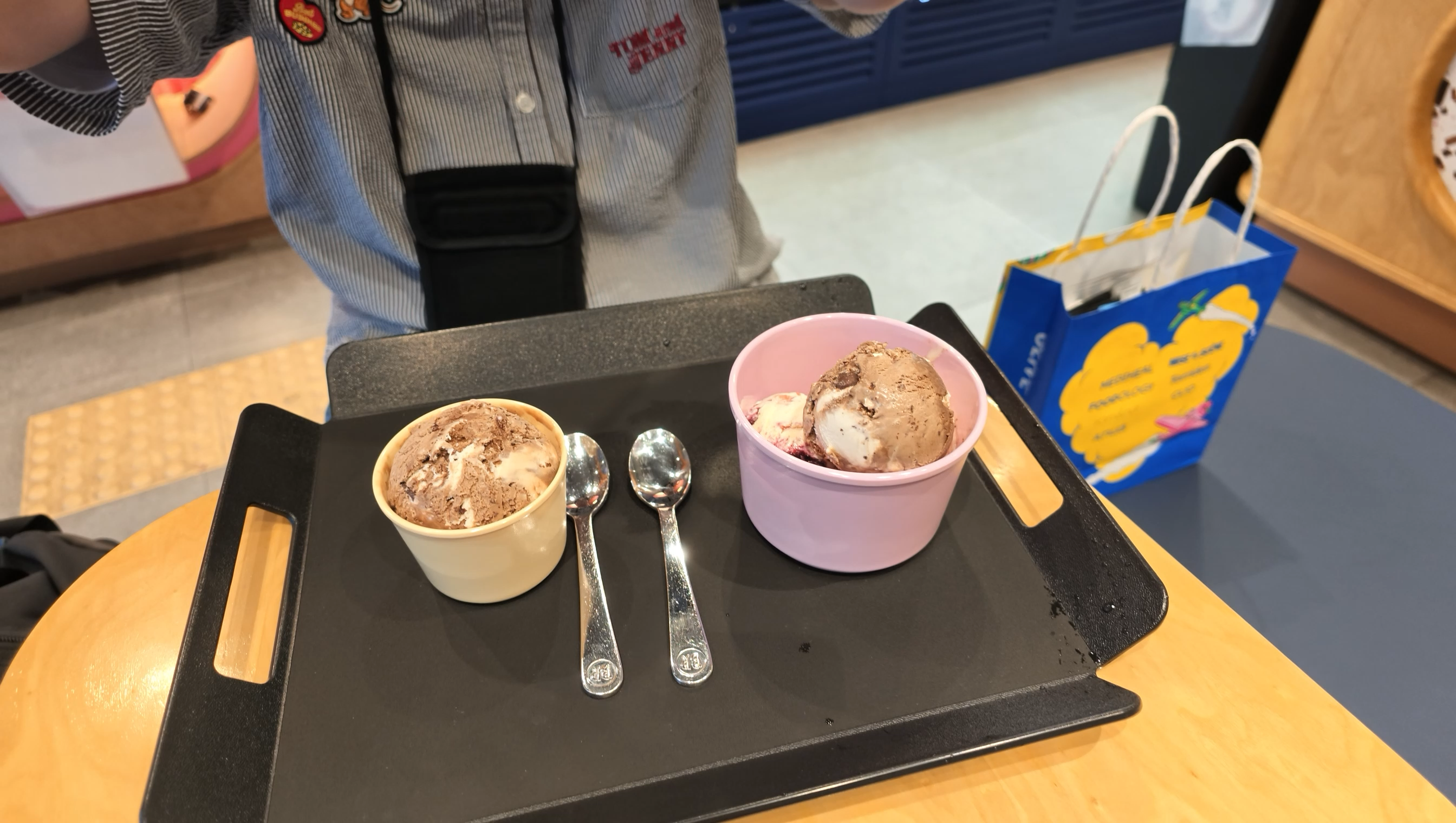 31で食べたアイス。黒いトレーに黄色とピンクのカップが並び、横にスプーンが添えられている
