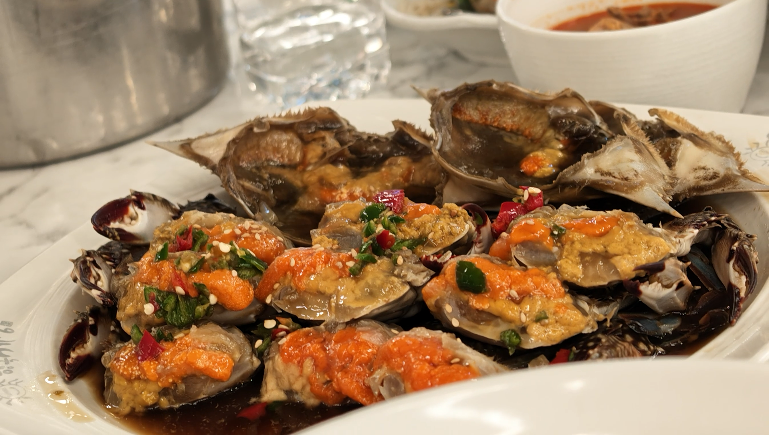 東大門で食べたカンジャンケジャン。醤油だれに漬かったカニが大皿に並び、卵やカニ味噌の上に唐辛子とゴマが添えられている