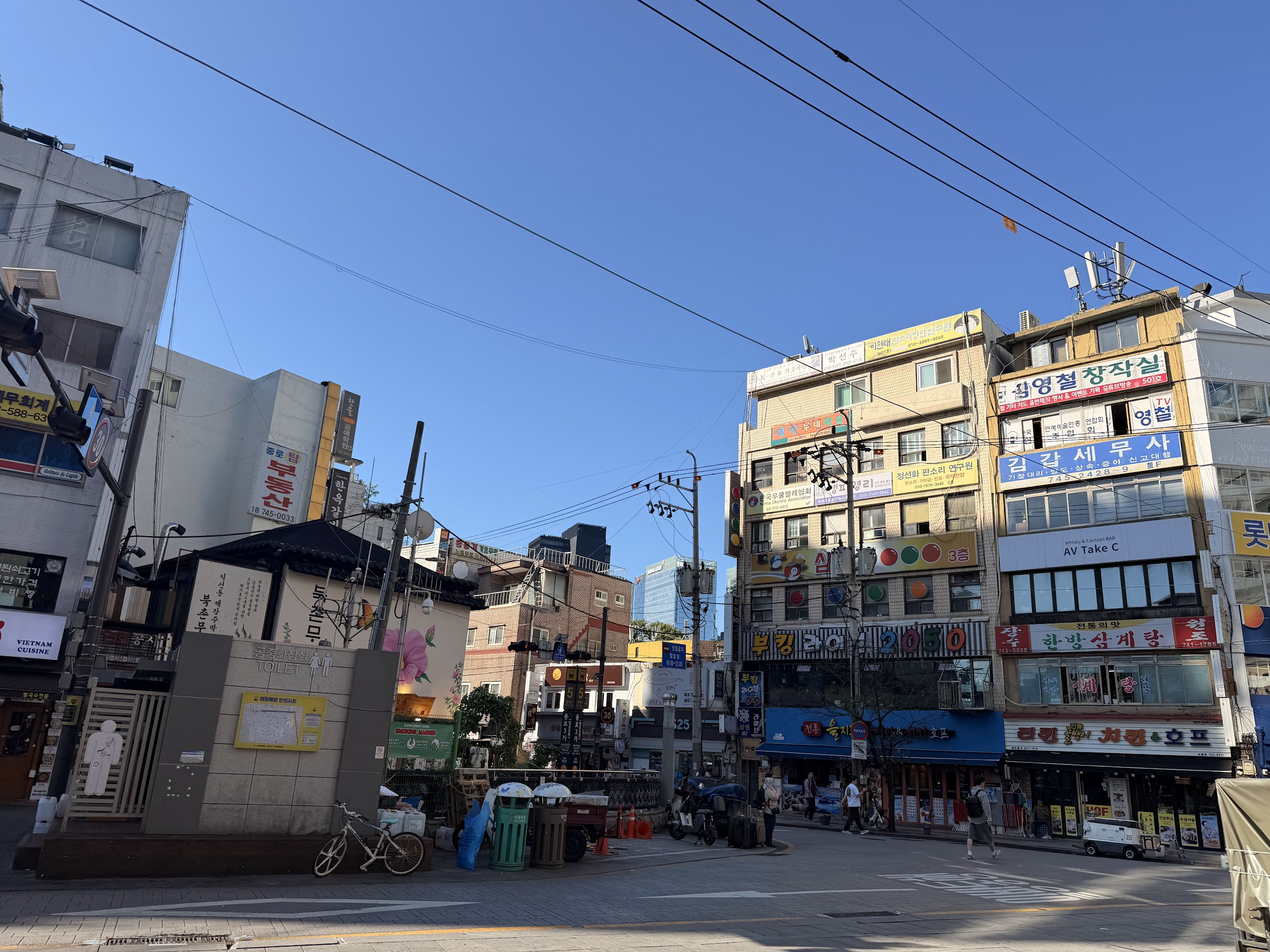 ホテル前の街並み。青空の下に、ハングルの看板が並ぶ建物や飲食店が見える